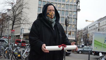 Eine Mietaktivistin mit den Forderungen der Initiative "Stop Heimstaden" in der Kurfürstenstraße.