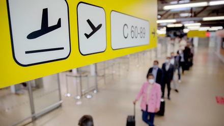 Passagiere stehen am Flughafen Berlin-Tegel vor der Sicherheitskontrolle Schlange.