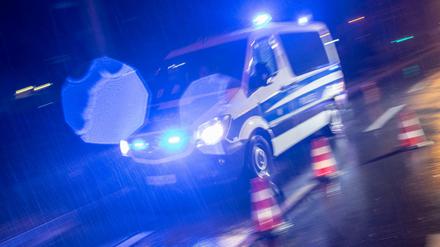 Ein Polizeifahrzeug fährt bei einer Schwerpunktkontrolle mit Blaulicht durch den Regen. Immer wieder kommt es dabei zu Unfällen mit Passanten.