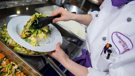 Köchin Nicole Graf serviert in der veganen Mensa auf dem Campus der Technischen Universität ein veganes Gericht mit Glasnudeln und Chinakohl.