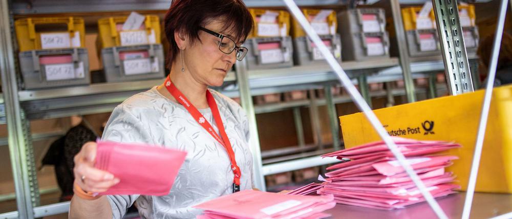 Eine Mitarbeiterin des Wahlamts sortiert Umschläge mit Briefwahlunterlagen. Die Briefwahlbeteiligung ist in Berlin so hoch wie nie.