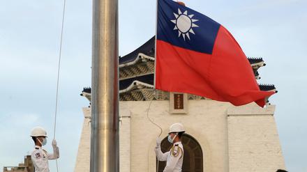 Zwei Soldaten senken die Nationalflagge während der täglichen Flaggenzeremonie auf dem Freiheitsplatz der Chiang Kai-shek Memorial Hall. 