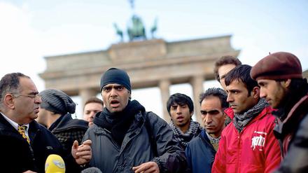 Der Übersetzer Reza (links) und der Asylbewerber Arash aus dem Iran (mitte) geben am 05.11.2012 in Berlin am Brandenburger Tor eine Pressekonferenz. Die Flüchtlinge protestieren gegen die Residenzpflicht, Sammelunterkünfte und die Asylpolitik in Deutschland.