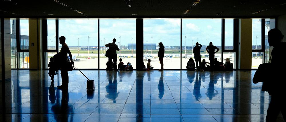 Wartende Flugpassagiere in dem Wartebereich des Terminals im BER Flughafens. 