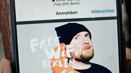 "Free WiFi Berlin" steht auf dem Bildschirm eines Handys am Brandenburger Tor. 