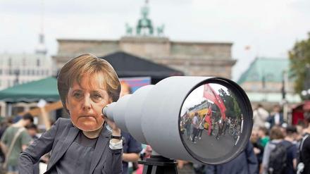 Den Bürger im Blick. Mit Teleskop-Attrappe und Merkel-Maske protestierten einige Tausend am Brandenburger Tor gegen staatliche Überwachung. 