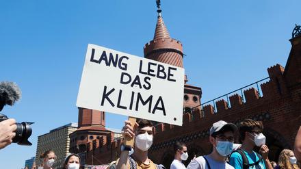 "Lang lebe das Klima"· steht auf dem Transparent eines Demonstranten, der mit vielen weiteren Klimaschützern über die Oberbaumbrücke geht. 