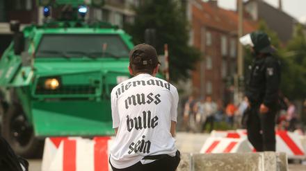 Ein Demonstrant und ein Berliner Polizist am Rande des G20 Gipfels in Hamburg