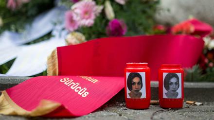 Kerzen mit Bildern von Hatun Sürücü stehen an dem Gedenkstein in Nähe des Tatortes in Berlin-Neukölln. 