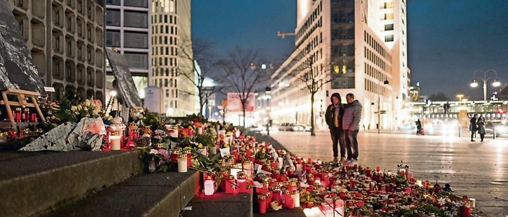 Blumen und Kerzen, die zum Gedenken an die Opfer vom Breitscheidplatz aufgestellt wurden, auf den Stufen zur Gedächtniskirche in Berlin zu sehen. 