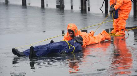 Gerade noch gerettet. Eingepackt in Überlebensanzüge demonstrieren Freiwillige der DLRG eine Rettung aus dem Eis.