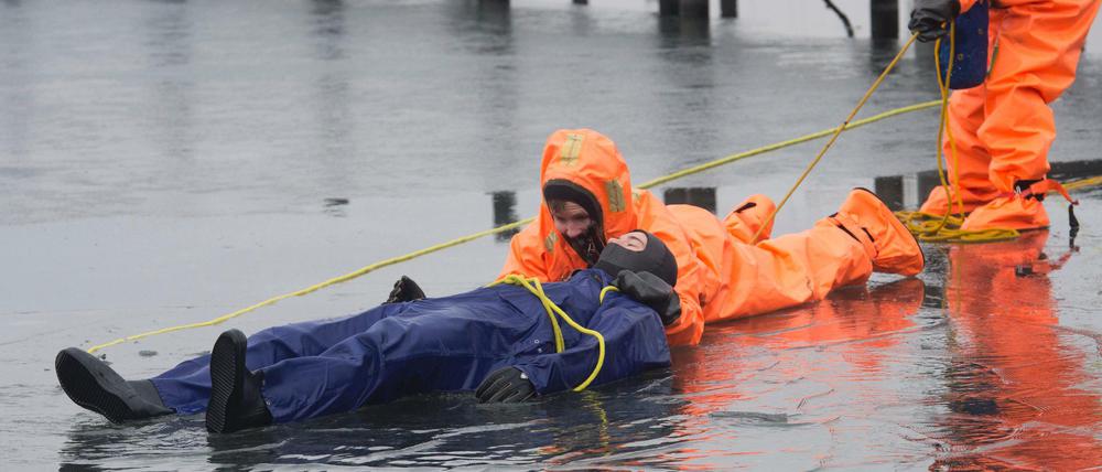 Gerade noch gerettet. Eingepackt in Überlebensanzüge demonstrieren Freiwillige der DLRG eine Rettung aus dem Eis.