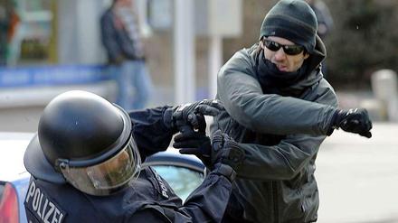 Ein gewalttätiger Demonstrant schlägt einen Polizisten nieder. Laut einer Potsdamer Studie wird die Gewaltbereitschaft gegen Polizeibeamte in Zukunft noch steigen - besonders von Seiten der rechtsextremen Szene. 