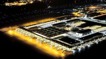 Hell erleuchtet, aber ohne Flugzeuge: Das neue Terminal des BER auf einem Nachtbild.
