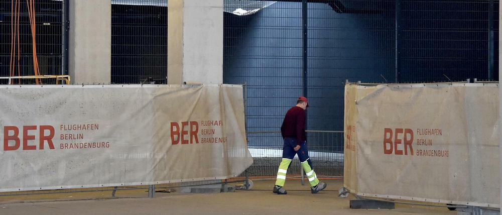 Ein Bauarbeiter geht in die Baustelle im Terminal des BER Flughafens Willy Brandt.