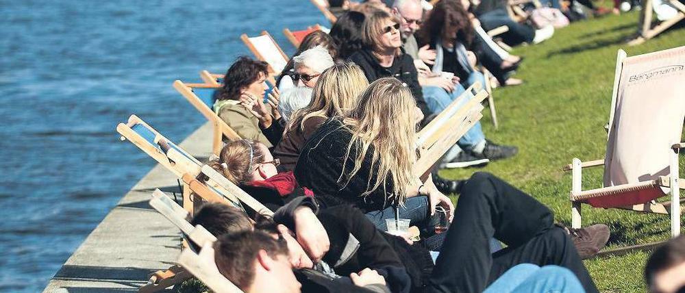 Alle am Fluss. Die Bar Capital Beach an der Spree hat bereits geöffnet, bei Sonnenschein machen es sich dort hunderte Menschen in den Liegestühlen bequem.
