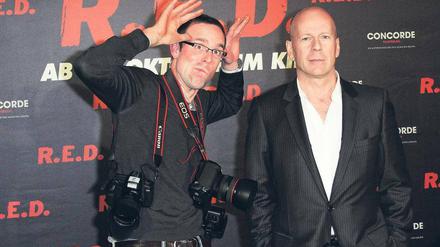 Fotofaxen. Genervt vom Blitzlichtgewitter holt Bruce Willis sich im Regent Hotel einen Fotografen an die Seite, der seinen Kollegen das Blitzen austreiben soll. Foto: Eventpress Radke