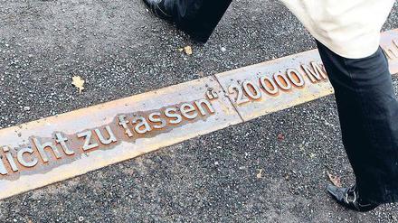 Auf dem Boden der Geschichte. Beschriftete Stahlbänder erinnern am neuen Gedenkort an der Bornholmer Straße an die Ereignisse vom 9. November 1989. Foto: Kumm/dpa