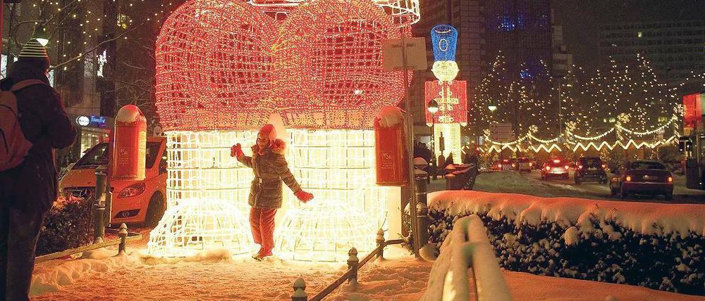 Schnee, schöne Lichter und Shopping-Stress: Auf dem Kurfürstendamm suchen Berliner nach den letzten Weihnachtsgeschenken. Der Handel reagiert zum Teil mit längeren Öffnungszeiten.