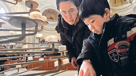 Gedenken im Dom. Auch Mikito Takefuji und der fünfjährige Tomoya entzündeten für die Erdbebenopfer eine Kerze. 