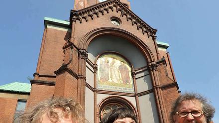 Strahlen um die Wette. Die Künstlerinnen Carolyn Krüger (l.) und Brigitte Kottwitz (Bildmitte) vor der Emmaus-Kirche. 