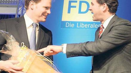 Fingerzeig. Der neue FDP-Landesvorsitzende Martin Lindner (r.) bedankte sich am Freitag nach seiner Wahl auf dem Landesparteitag bei seinem Vorgänger Christoph Meyer mit einer Flasche Rotwein. Die Berliner FDP trifft sich zu einem zweitägigen Parteitag.