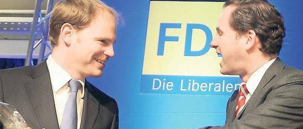 Fingerzeig. Der neue FDP-Landesvorsitzende Martin Lindner (r.) bedankte sich am Freitag nach seiner Wahl auf dem Landesparteitag bei seinem Vorgänger Christoph Meyer mit einer Flasche Rotwein. Die Berliner FDP trifft sich zu einem zweitägigen Parteitag.