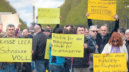 Fahrer aller Berliner Taxiverbände protestierten am Montag gegen die Gebühren am BER. Tausende blockierten die Straße des 17. Juni.Fotos: Ch. Mang/dpa, Schuh