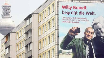 Und sie lächeln und lächeln und lächeln. DJ Paul van Dyk und Willy Brandt sind die Botschafter des Flughafens – und auch die Gesichter der aktuellen Krise.