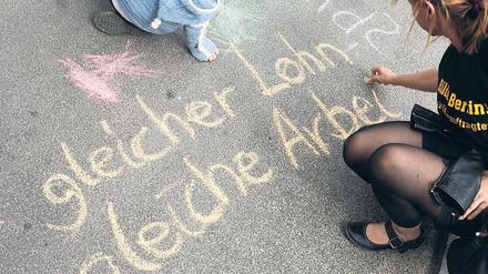 Tafelkreide auf der Straße. Mehrere hundert Lehrkräfte zogen am Donnerstag vor die Senatsverwaltung für Bildung am Alexanderplatz, um für bessere Bezahlung zu demonstrieren. Manche Eltern nahm auch ihr Kind mit. 