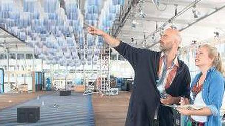 So wird’s gemacht. Kreativberater Arne Koefoed und eine Mitarbeiterin beim Messeaufbau. An der Decke hängen 1000 in Tauchbädern weißblau gefärbte Shirts.