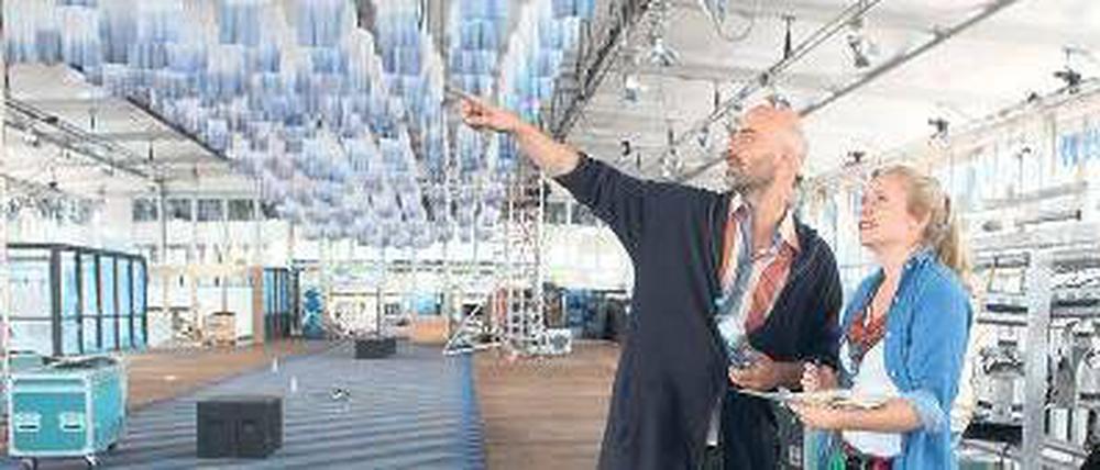 So wird’s gemacht. Kreativberater Arne Koefoed und eine Mitarbeiterin beim Messeaufbau. An der Decke hängen 1000 in Tauchbädern weißblau gefärbte Shirts.