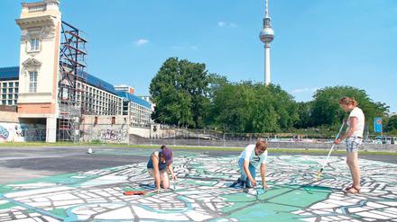 Weltstadt-Malerei. Junge Künstler aus Deutschland, Spanien, Frankreich und vielen anderen Ländern arbeiten auf dem Schlossplatz an einem Riesenplan von Berlin. Zur 775-Jahr-Feier soll er mit zahlreichen Beispielen dokumentieren, wie Einwanderer die Stadt zu dem gemacht haben, was sie heute ist. 