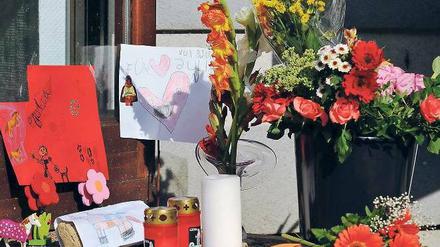 Stille Trauer. Blumen, Kerzen und Abschiedsbriefe vor dem Unglückshaus. F.: dapd