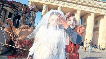 Grausige Gestalten. Die „Weiße Frau“ und ein Pestkranker tummeln sich für den „Berlin Dungeon“ am Brandenburger Tor. Foto: Davids