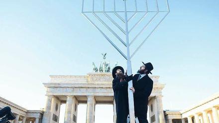 Glaubensbekenntnis. Gemeinsam haben die Rabbiner Yehuda Teichtal (rechts) und Shmuel Segal gestern auf dem Pariser Platz einen sechs Meter hohen Chanukka-Leuchter aufgestellt. Angezündet wird er aber erst am morgigen Sonntag um 18.30 Uhr. 