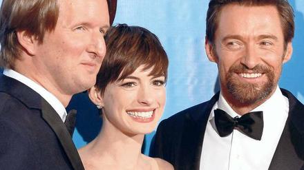 Das Lächeln der Stars. Regisseur Tom Hooper bringt bringt neben seinem Film "Les Misérables" auch die Darsteller Anne Hathaway und den bärtigen Hugh Jackman mit. 