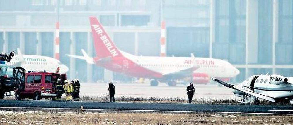 Am Unfallort. Rettungskräfte eilten zum Flugzeug, das ins Gras gerutscht war. Im Hintergrund ist der neue BER-Terminal zu erkennen. Foto: dpa