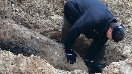 Fund mit Folgen. Ein Polizeifeuerwerker untersucht die Bombe auf der Baustelle in der Hubertusallee in Schmargendorf. Foto: dpa