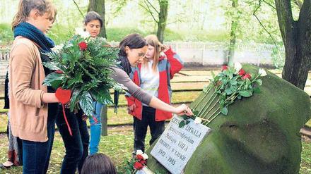 An historischem Ort. Schülerinnen aus Berlin und Zgorzelec legen am Gedenkstein für die Opfer des Kriegsgefangenenlagers bei Görlitz Blumen nieder. 