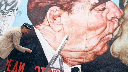 Die Kritzeleien müssen weg: Maler Dimitri Vrubel hat sein Bild „Bruderkuss“ zuletzt im April 2014 gereinigt. Mit der Aufnahme in die Stiftung Berliner Mauer wäre nicht nur die aktuell nötige Reinigung finanziell gedeckt. 