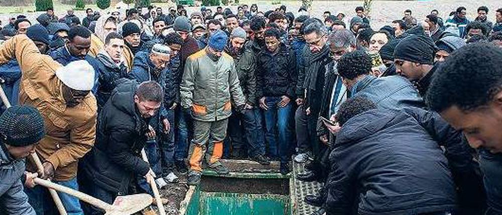 Gemeinsam bestattet. Freunde und Angehörige schaufeln Erde auf den Sarg von Khaled Idris Bahray. Beigesetzt wurde der junge Asylbewerber aus Dresden auf dem islamischen Teil des Landschaftsfriedhofs Gatow im Süden Spandaus. 