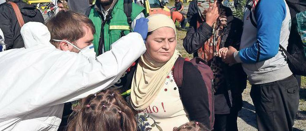 Erste Hilfe. Ein Mediziner des Deutschen Roten Kreuzes untersucht am Bahnhof Schönefeld eine Frau aus Syrien, die mit dem Zug aus München angekommen ist. 