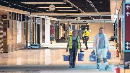 Bauarbeiter gehen am 15.10.2015 durch das Terminalgebäude des Hauptstadflughafens Berlin Brandenburg Willy Brandt (BER) in Schönefeld (Brandenburg). 