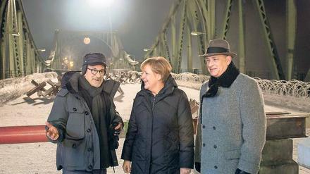 Auch Kanzlerin Angela Merkel hat ein Faible für Drehorte, wie sie beim Besuch auf der Glienicker Brücke am Set von Steven Spielbergs „Bridge of Spies“ zeigte. Tom Hanks (rechts) hat’s gefreut. 