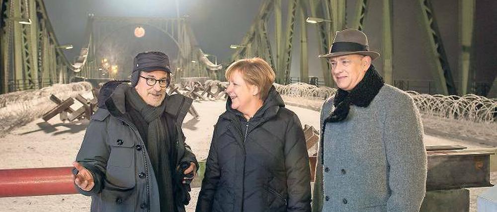 Auch Kanzlerin Angela Merkel hat ein Faible für Drehorte, wie sie beim Besuch auf der Glienicker Brücke am Set von Steven Spielbergs „Bridge of Spies“ zeigte. Tom Hanks (rechts) hat’s gefreut. 