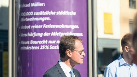 Michael Müller vor einer lila Litfaßsäule mit seinen Miet-Botschaften.