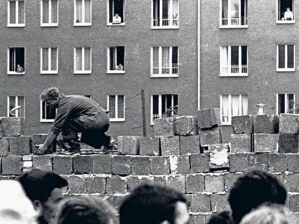 Eingemauert. Ost-Berliner betrachten aus ihren Wohnungen, wie die Mauer in die Höhe wächst. 