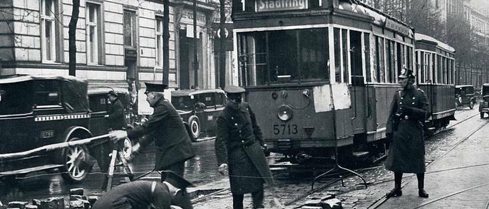 Unter Polizeischutz. BVG-Bedienstete räumen Straßenbahnschienen frei, die von Streikenden 1932 mit Steinen blockiert worden waren. 