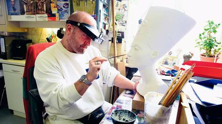 Gipskunstformer Sandro Michele bemalt ein 8900 Euro teures Replikat der Nofretete-Büste.